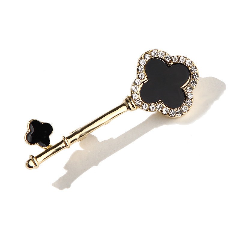 Broszka w kształcie klucza z motywem czterolistnej koniczyny