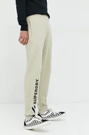 Spodnie męskie - Superdry spodnie dresowe bawełniane męskie kolor beżowy z aplikacją - miniaturka - grafika 1