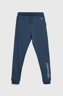 Spodnie i spodenki dla chłopców - Calvin Klein Jeans spodnie dresowe bawełniane dziecięce kolor granatowy z nadrukiem - grafika 1