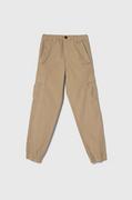 Spodnie i spodenki dla chłopców - Guess spodnie bawełniane dziecięce kolor beżowy gładkie - miniaturka - grafika 1