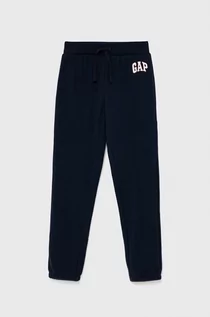 Spodnie i spodenki dla dziewczynek - Gap spodnie dresowe dziecięce kolor granatowy gładkie - - grafika 1