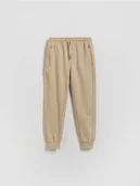 Spodnie i spodenki dla chłopców - Reserved - Bawełniane joggery - beżowy - miniaturka - grafika 1