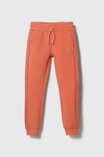 Spodnie i spodenki dla dziewczynek - Guess spodnie dresowe dziecięce kolor pomarańczowy gładkie - grafika 1