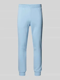 Spodnie dresowe o kroju slim fit z naszywką z logo - Spodnie sportowe męskie - miniaturka - grafika 1