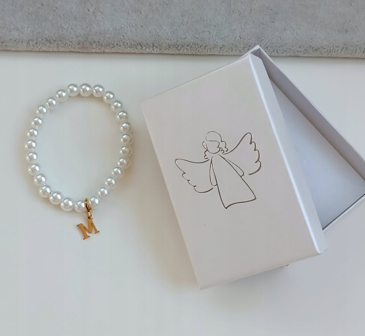 DZIECIĘCA BRANSOLETKA NA GUMCE PERŁY Z LITERKĄ + PUDEŁKO STAL KOMUNIA ANIOŁ