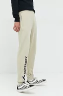 Spodnie męskie - Superdry spodnie dresowe bawełniane męskie kolor beżowy z aplikacją - miniaturka - grafika 1