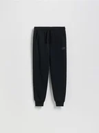 Spodnie i spodenki dla chłopców - Reserved - Joggery z bawełną - czarny - miniaturka - grafika 1