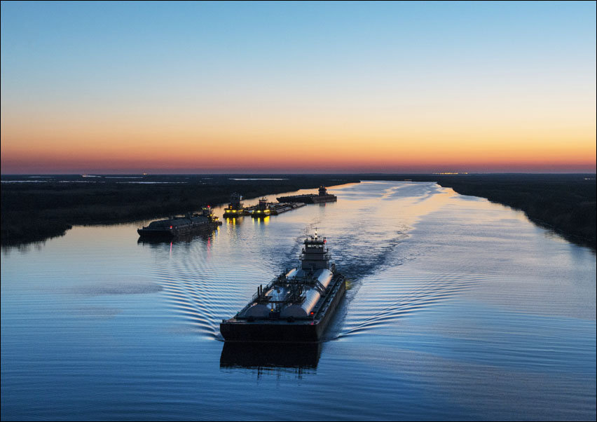 Dusk shot of barges traversing a short canal that connects the Sabine Pass waterway separating Texas from Louisians, and the Trinity River, south of P