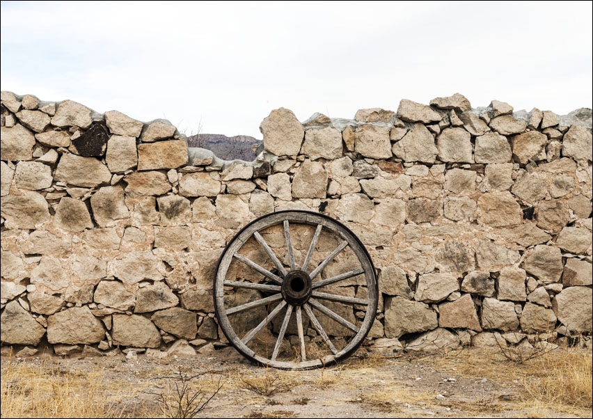 Wagon wheel against a stone fence at Hueco Tanks State Park, northwest of El Paso, USA, Carol Highsmith - plakat 70x50 cm