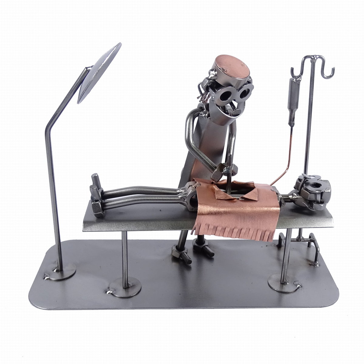 Metalowa figurka Pani chirurg podczas operacji