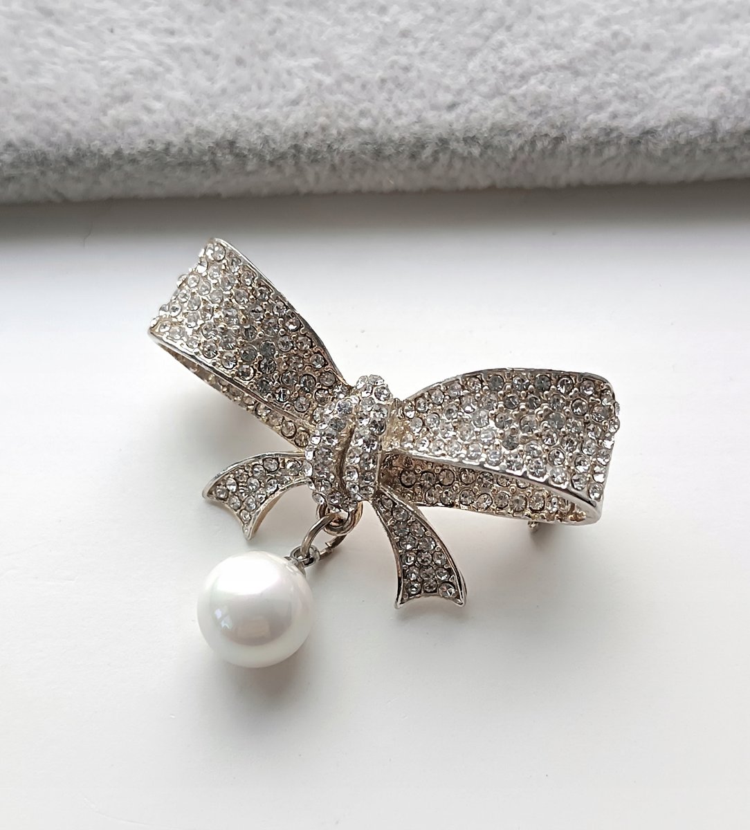 SREBRNA BROSZKA KOKARDA KOKARDKA WISZĄCA PERŁA BIAŁE CYRKONIE PRZYPINKA