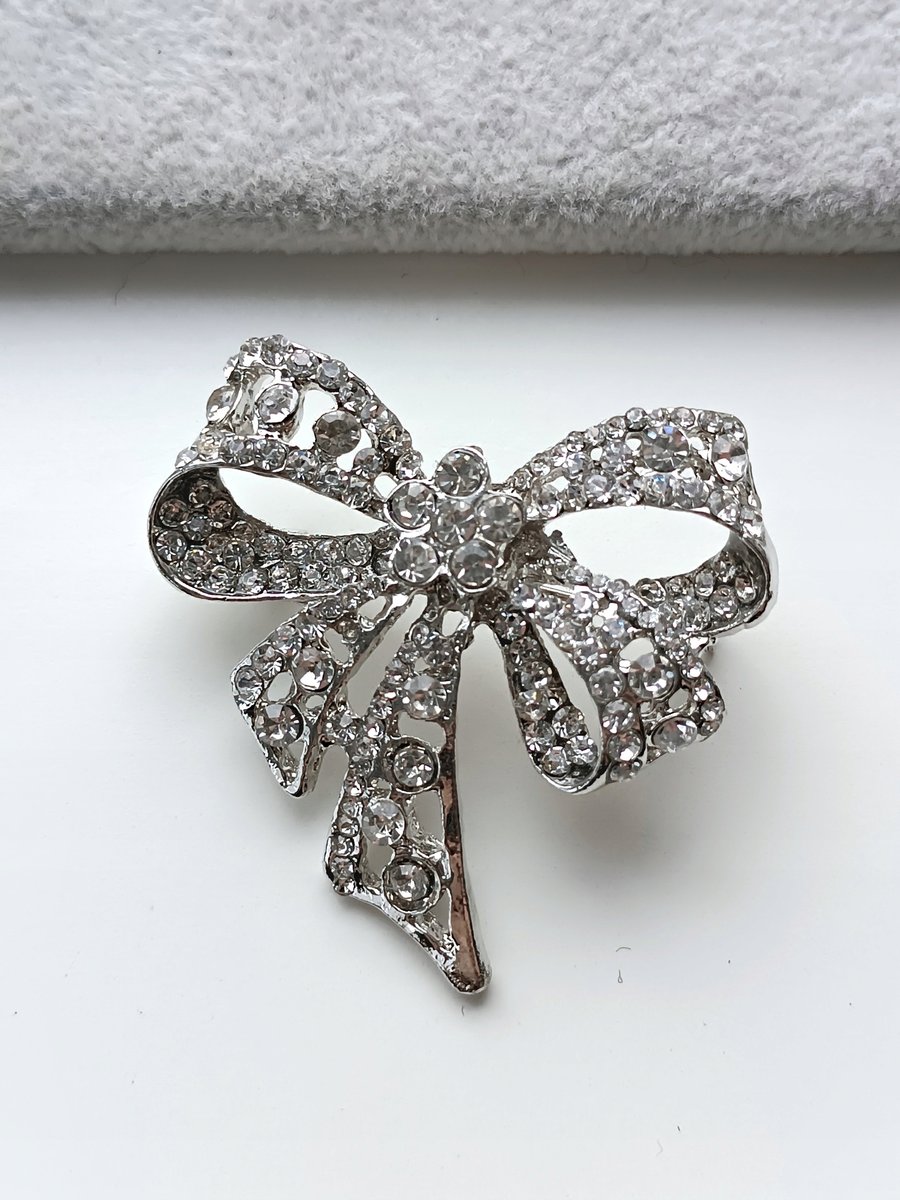 SREBRNA BROSZKA KOKARDA KOKARDKA BIAŁE CYRKONIE PRZYPINKA PIN