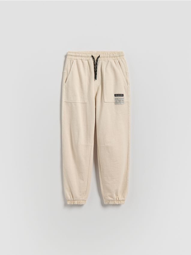 Reserved - Joggery z efektem sprania - kremowy