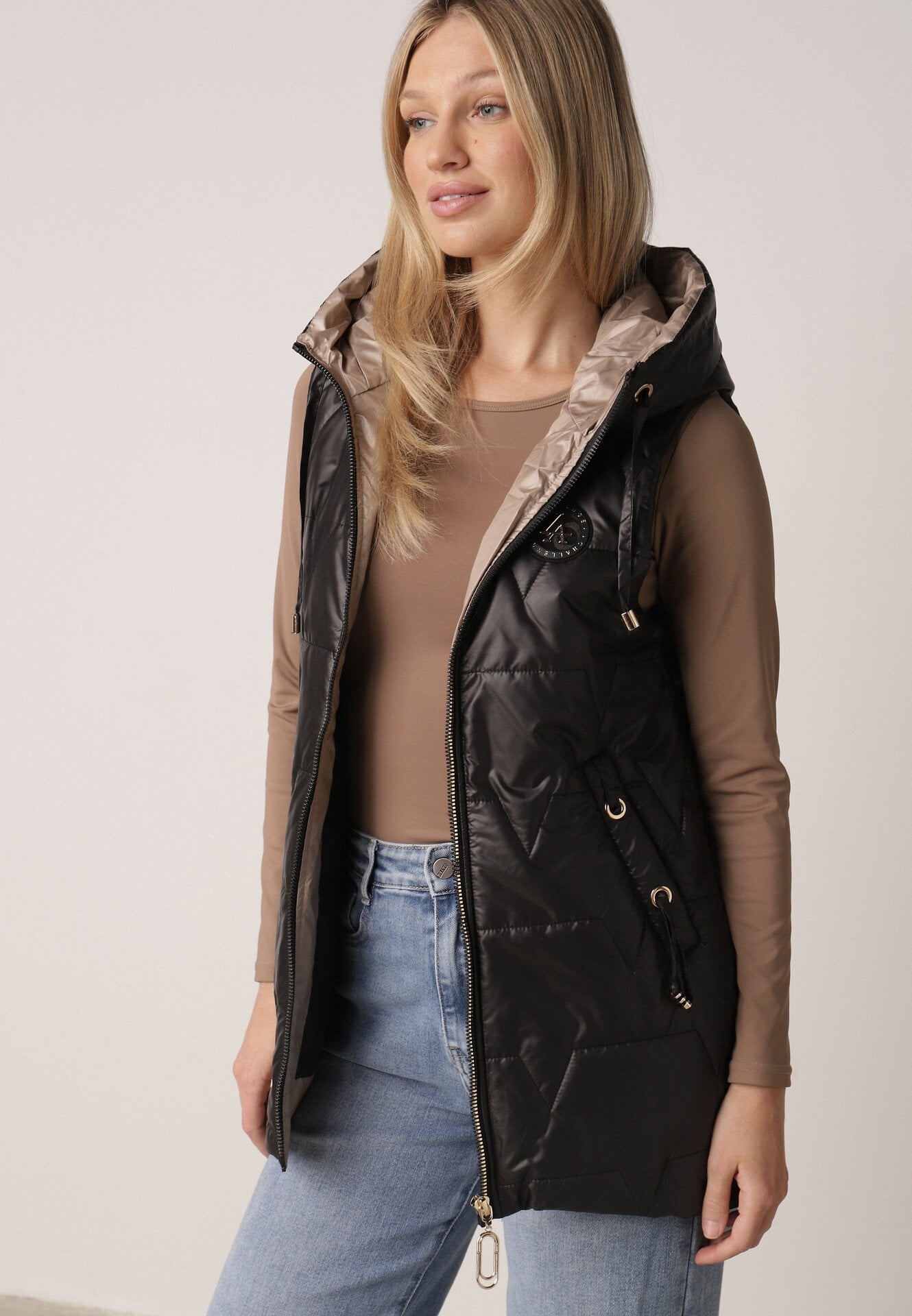 Czarna Pikowana Kamizelka o Długim Kroju z Nieodpinanym Kapturem i Aplikacją Koretes