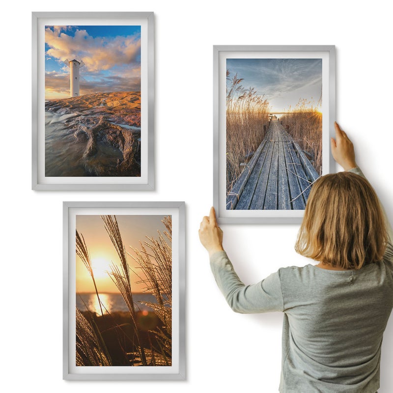 Galeria ścienna 3-częściowy komplet obrazów w srebrnych ramach - Widok latarni morskiej nad morzem trawa i drewniany pomost - ArtPrintCave