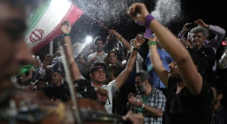 Supporters of newly re-elected Iranian President Hassan Rouhani dance during a gathering to celebrate his victory at the Vanak square in downtown Tehran on May 20, 2017