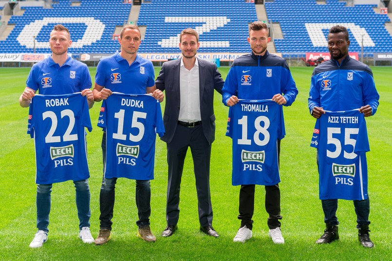 Piłkarze Marcin Robak (L) i Dariusz Dudka (2L) wiceprezes "Kolejorza" Piotr Rutkowski (C) oraz Denis Thomalla (2P) i Abdul Aziz Tetteh (P) pozują do zdjęć na stadionie po konferencji prasowej, na której przedstawiono nowych zawodników Lecha Poznań