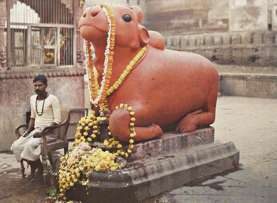 Posąg Nandina, byka, który wedle mitologii miał być wierzchowcem hinduskiego boga Śiwy. Zdjęcie wykonane w mieście Waranasi (fot. Stéphane Passet, 29 stycznia 1914 r., domena publiczna).