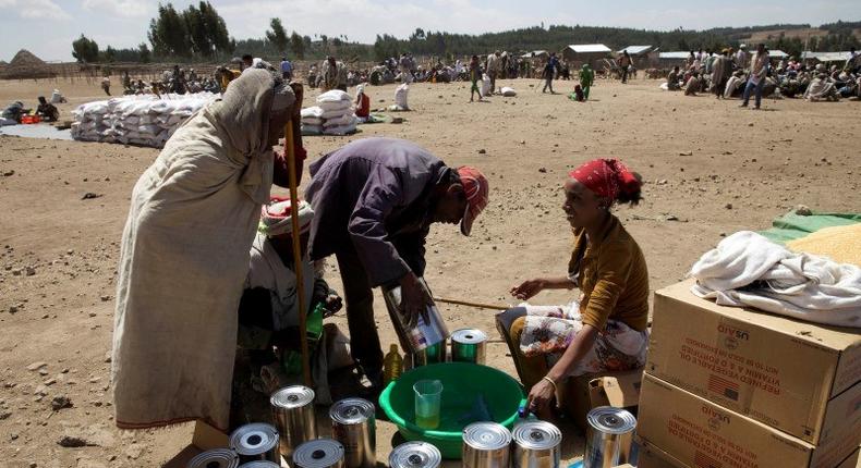 An elderly woman receives cooking oil at an emergency food aid distribution in the village of Estayish in Ethiopia's northern Amhara region, February 11, 2016. REUTERS/Katy Migiro