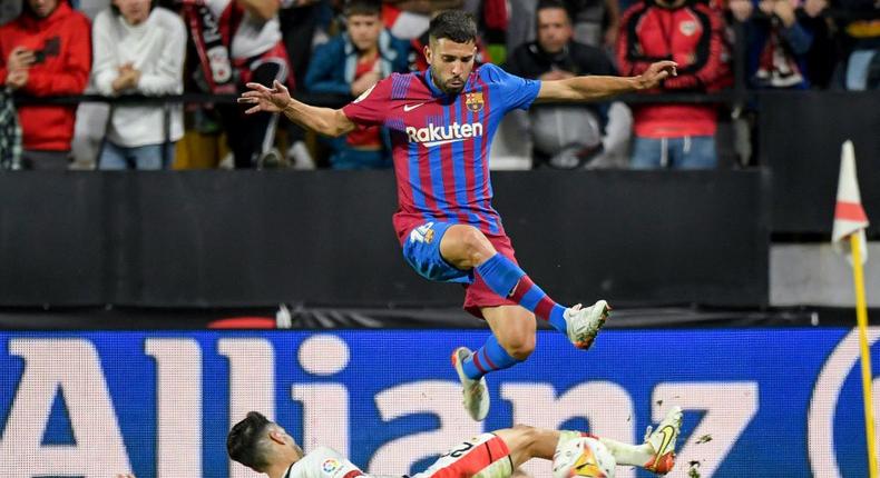 Barcelona defender Jordi Alba jumps over Rayo Vallecano's Oscar Valentin on Wednesday. Creator: OSCAR DEL POZO