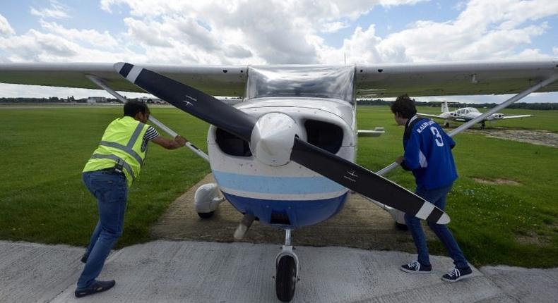 Pilot Somasekhara Pemmireddy (L) and passenger Adam Nicholas park the plane after a flight over the capital in a Cessna 172 plane, at the London North Weald airfield on August 1