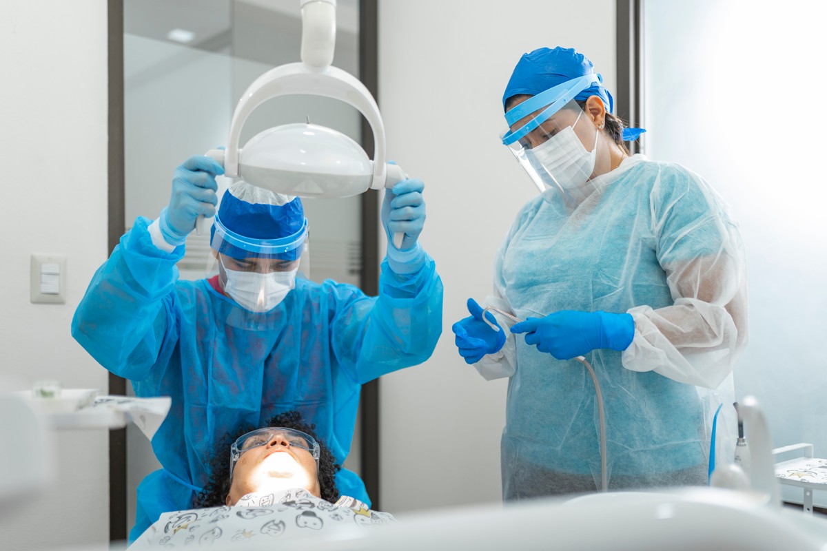 Dentist,And,Assistant,Wearing,Ppe,Attending,To,A,Patient,In