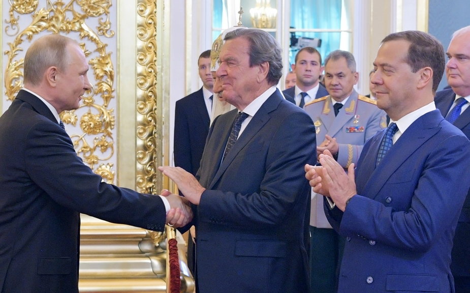 Prezydent Rosji Władimir Putin (L) podaje rękę byłemu kanclerzowi Niemiec Gerhardowi Schroederowi  podczas zaprzysiężenia Putina na kolejną kadencję. 7.05.2018