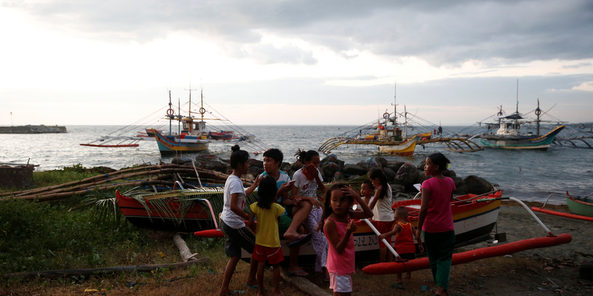 Residents gather near fishing boats that just returned from disputed Scarborough Shoal, as they are docked at the coastal village of Cato in Infanta, Pangasinan in the Philippines, October 31, 2016.