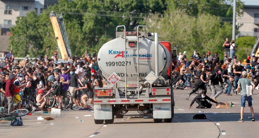 Protesters scale a truck that was driven into a rally