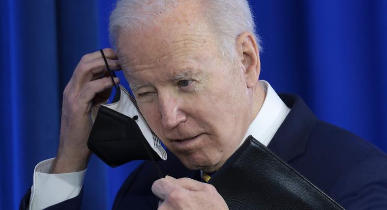 Joe Biden removes his mask before speaking at an event.