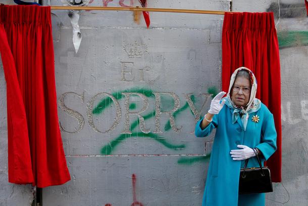 A person, dressed as Britain's Queen Elizabeth II, gestures during an event ahead of the anniversary