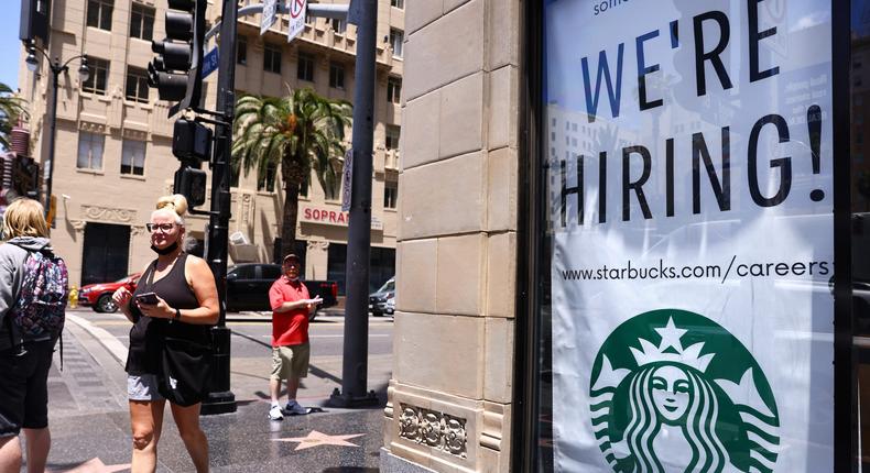A 'We're Hiring!' sign is displayed at a Starbucks on Hollywood Boulevard on June 23, 2021 in Los Angeles, California.
