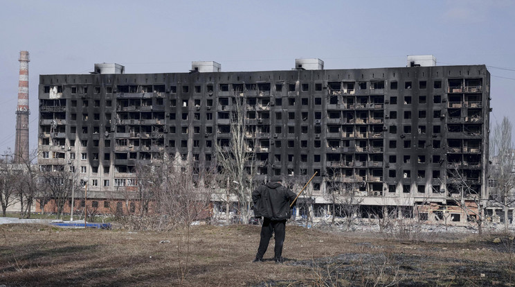 Tüzérségi támadásban megrongálódott lakóházat néz egy férfi Mariupolban 2022. március 13-án / Fotó: MTI/AP/Jevhen Maloletka