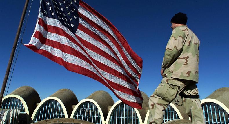 A solider looks at the US flag.
