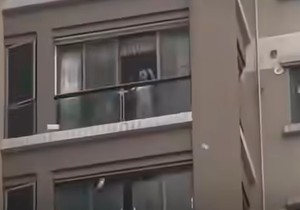 Bacila novac sa balkona zgrade