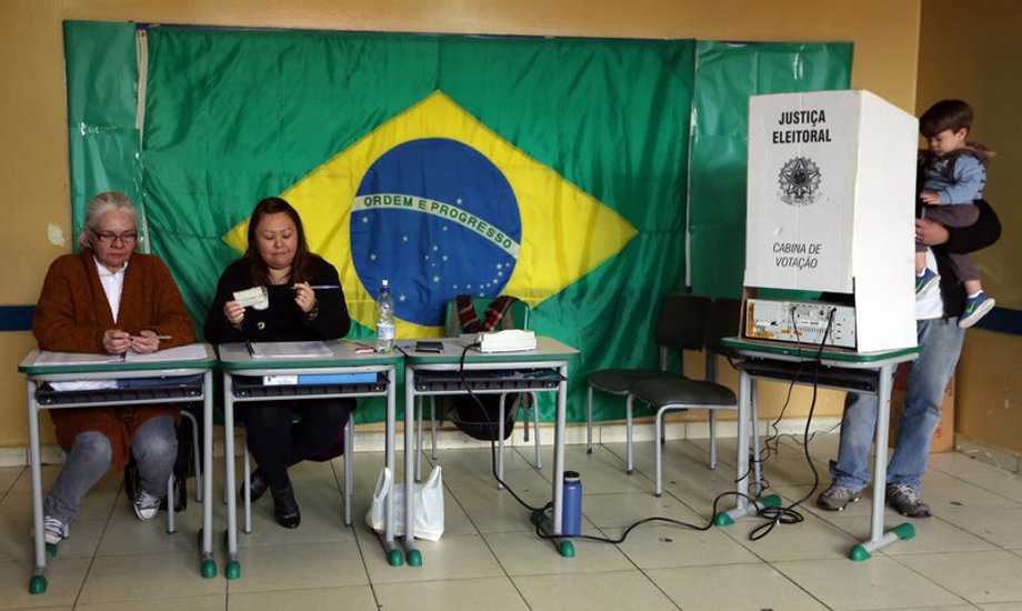 A man carrying a baby votes during municipal elections in Sao Bernardo do Campo, Brazil, October 2, 2016.