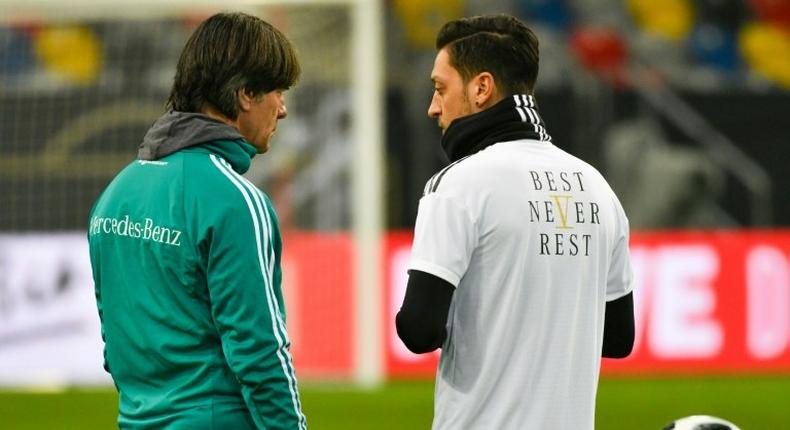 Germany head coach Joachim Loew (L) talks to midfielder Mesut Ozil during a training session last March. Ozil quit international duty in July, citing racism and disrespect within the German FA (DFB) and has reportedly broken contact with Loew.