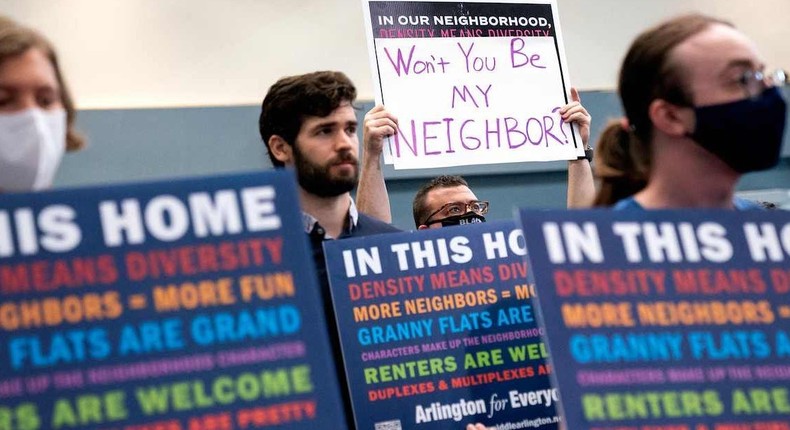 A demonstrator holds up a sign that says Won't you be my neighbor?, a quote from the children's show Mister Rogers' Neighborhood, during the Arlington County board meeting in Arlington, Virginia, on July 16, 2022.Stefani Reynolds/Getty Images