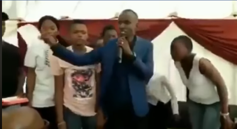 “My name is prophet Nicholas, son of prof Daniel – Pastor brags as he tears bible, feeds it to members (video)