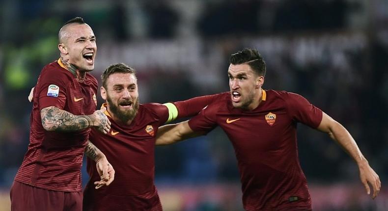 Roma's midfielder Radja Nianggolan (C) celebrates with teammates after scoring during the Italian Serie A football match Roma vs AC Milan at the Olympic Stadium in Roma on December 12, 2016