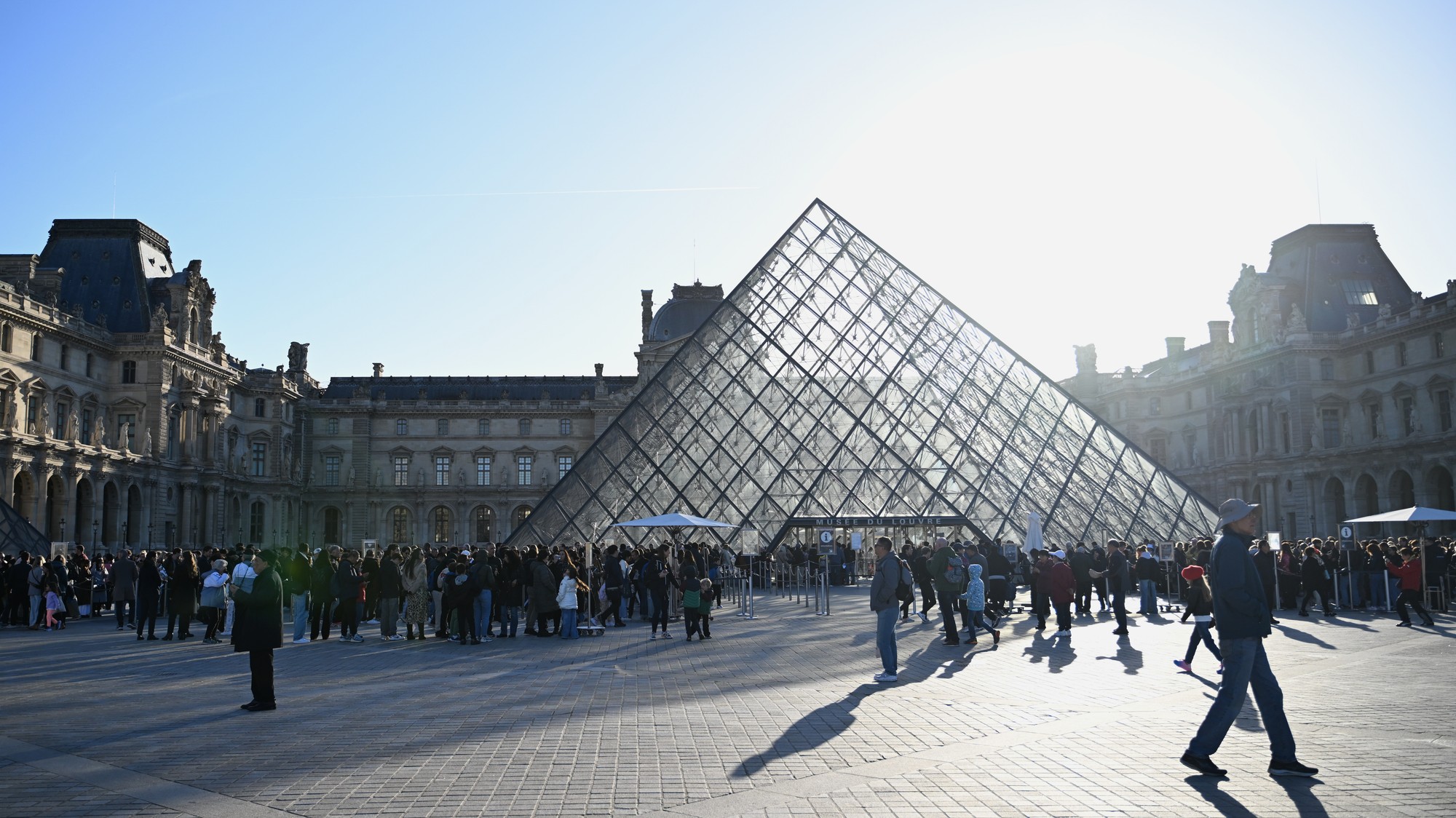Ľudia čakajú v rade na vstup do múzea Louvre.