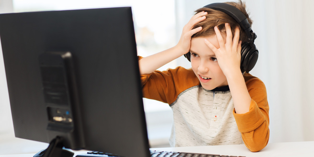 terrified boy with computer and headphones at home