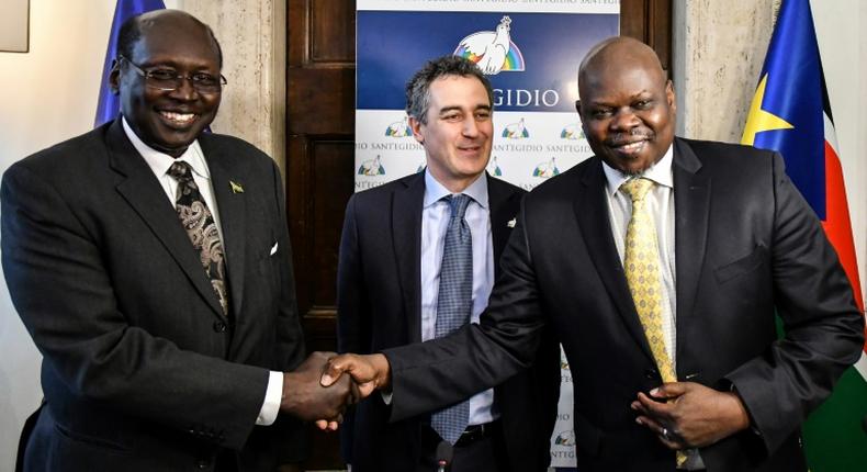 South Sudanese  presidential advisor Barnaba Marial Benjamin (L) shakes hands with the co-founder of South Sudan Reborn, Pagan Amum (R) as the Community of Sant'Egidio's International Relations Office Paolo Impagliazzo (C) looks on