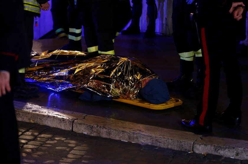 Fire fighters and medical staff member carry an injured person outside the underground where some of