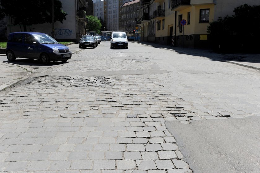 Ulica z kostki brukowej połatana asfaltem