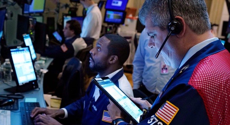 Traders Aaron Ford, left, and John Panin work on the floor of the New York Stock Exchange wall street stocks