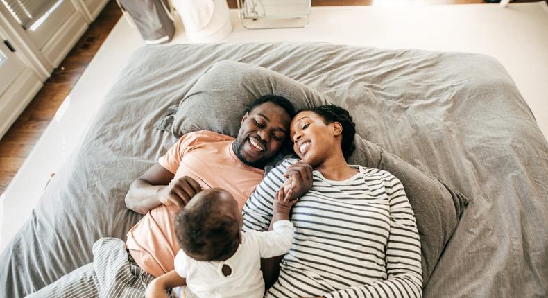 family with baby lying on the bed