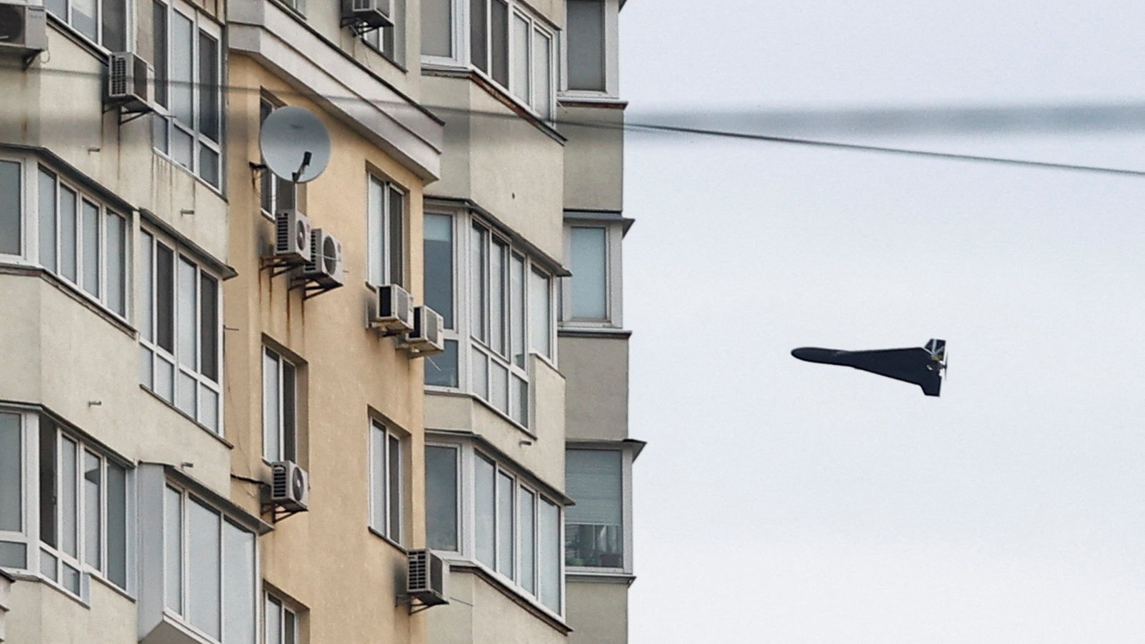 Ruský kamikadze dron Geran 2 letí vedľa budovy počas ruských útokov na ukrajinský Kyjev.