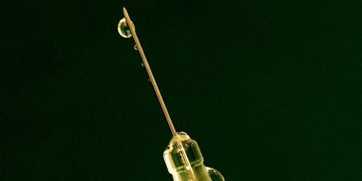 A flu vaccine drips out of a syringe as a nurse prepares for a patient at a clinic in central London. One day, we might be able to have a vaccine like this approved for HIV.