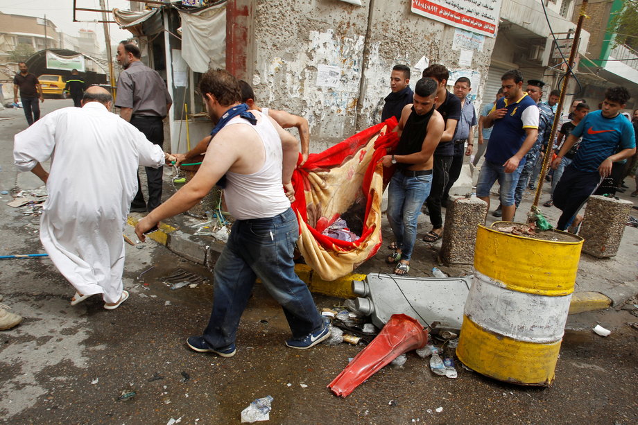 Civilians with the body of a victim killed in the suicide car bombing.